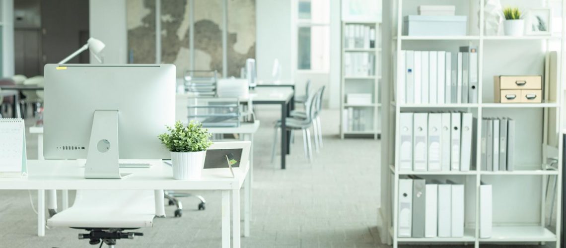 Interior of a modern office with computer and white furniture