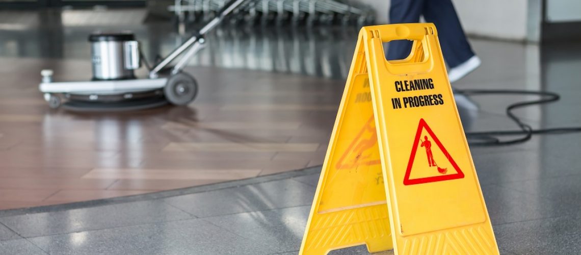 Woman worker cleaning the floor with polishing machine